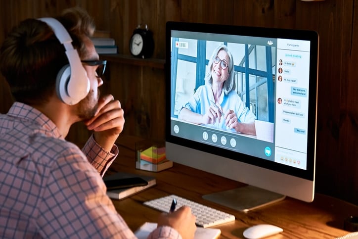 A person on a video call at a desktop computer